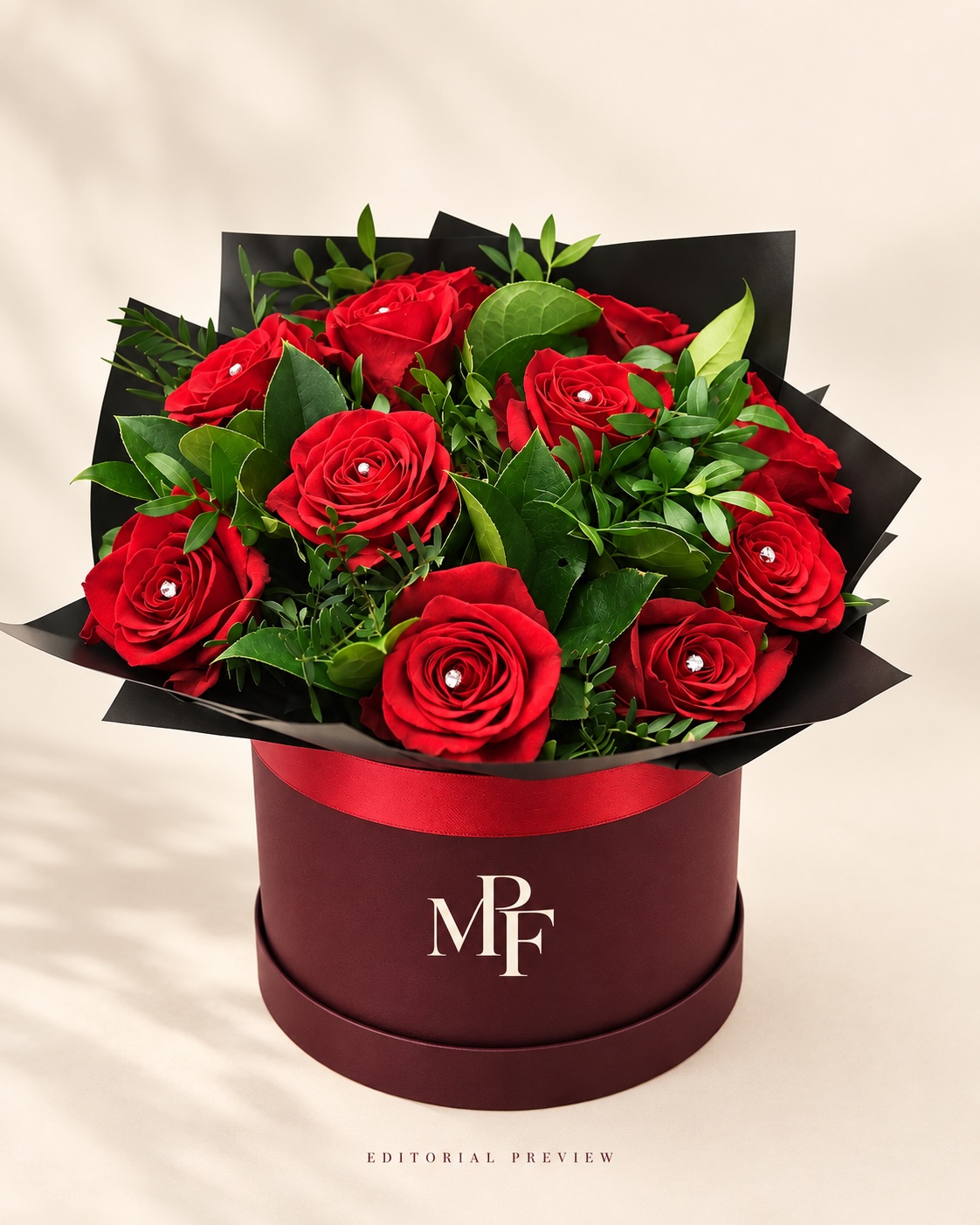 Red roses and green foliage in a burgundy MPF hatbox with a red ribbon
